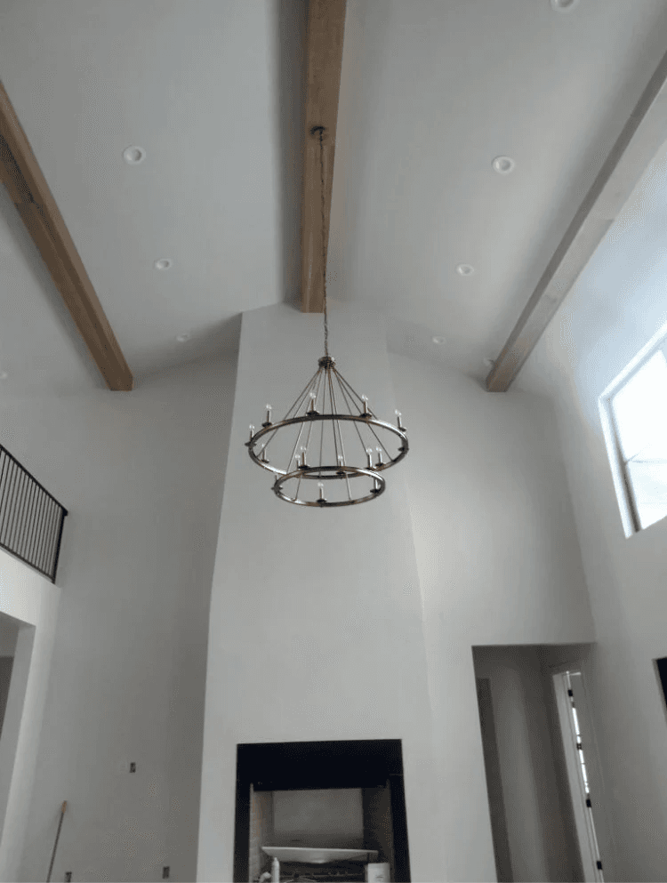 Two-tier chandelier hung in a vaulted great room by High Desert Electric